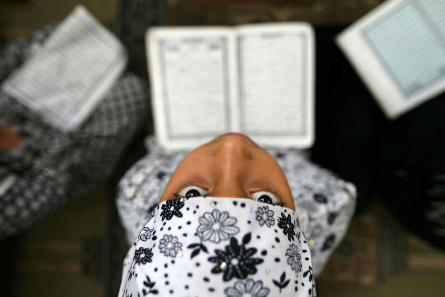 دختری در حال خواندن قرآن در مسجدی در نوار غزه در منطقه RAFAH عکاس: Ibraheem Abu Mustafa مکان: RAFAH، فلسطین 