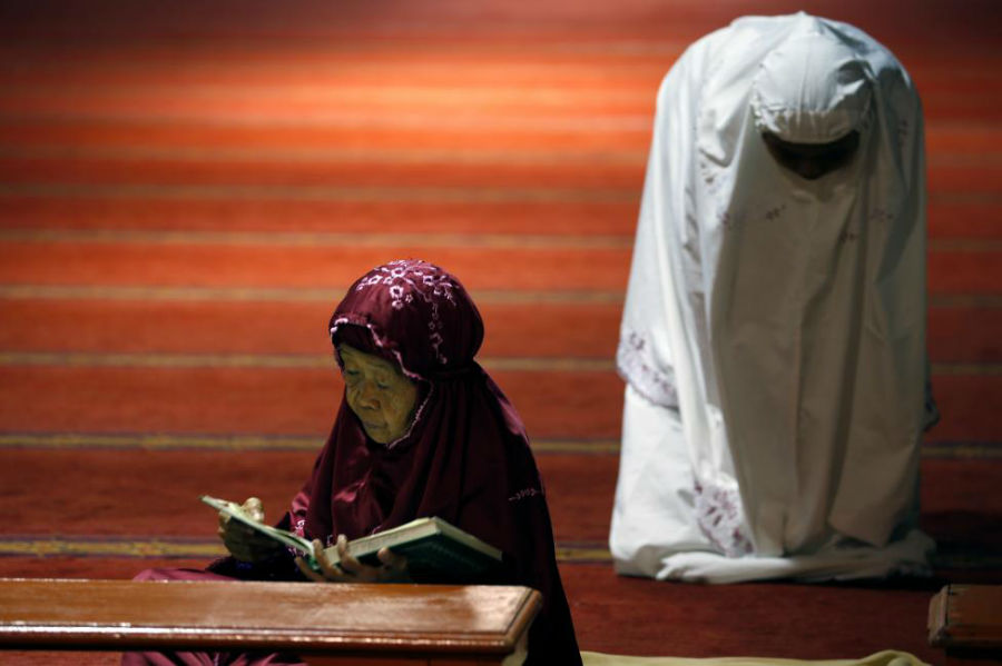 زن مسلمان در حال خواندن قرآن در روز اول ماه رمضان در مسجد استقبال در جاکارتا عکاس: Beawiharta Beawiharta مکان: جاکارتا، اندونزی 