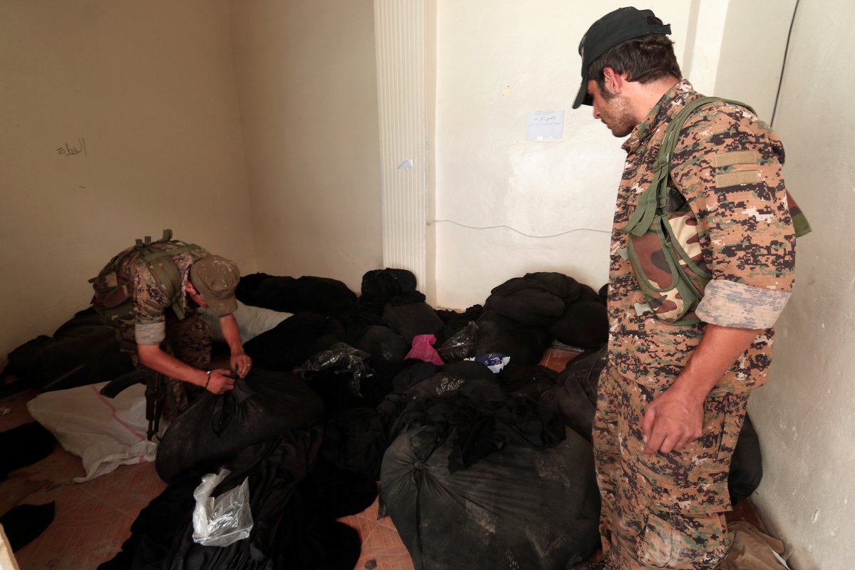 sdf-fighters-inspect-bags-of-niqabs-at-a-center-that-was-used-by-isis-religious-police-or-al-hisbah-in-manbij