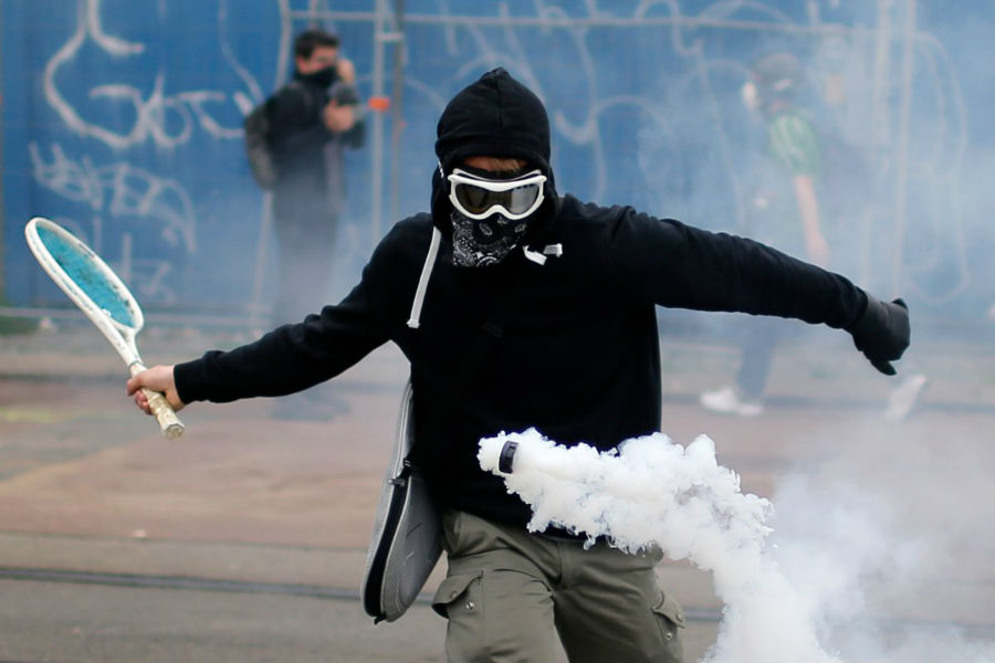 معترضی که در طول راهپیمائی های اعتراض آمیز به طرح قانون کار دولت، از راکت تنیس برای برگرداندن گازهای اشک آور استفاده می کند، فرانسه - 2 ژوئن