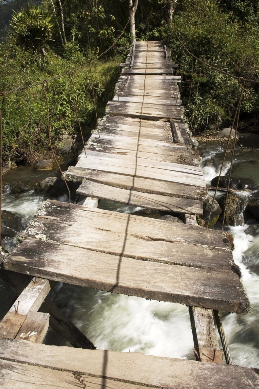 Bridge over the river Irubi. Old wooden bridge with missing parts.Valley of the river Irubi Imbabura Ecuador