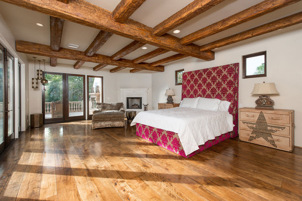 تختخوابی با طرح برجسته و زرشکی و سقفی که با الوارهای چوبی مزین شده، یکی از اتاق خواب های این خانه را تشکیل داده اند.