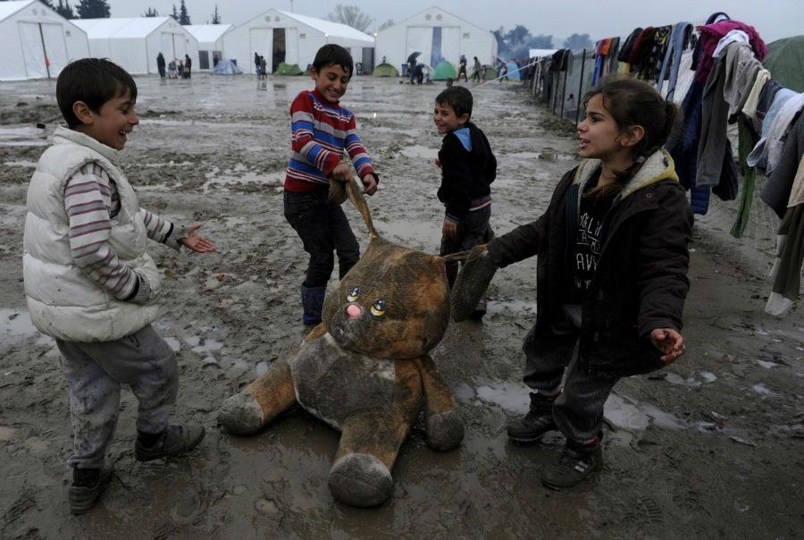 کودکان پناهنده ها در حال بازی با یک عروسک در کمپ پناهجویان در مرز یونان و مقدونیه - 15 مارس 2016