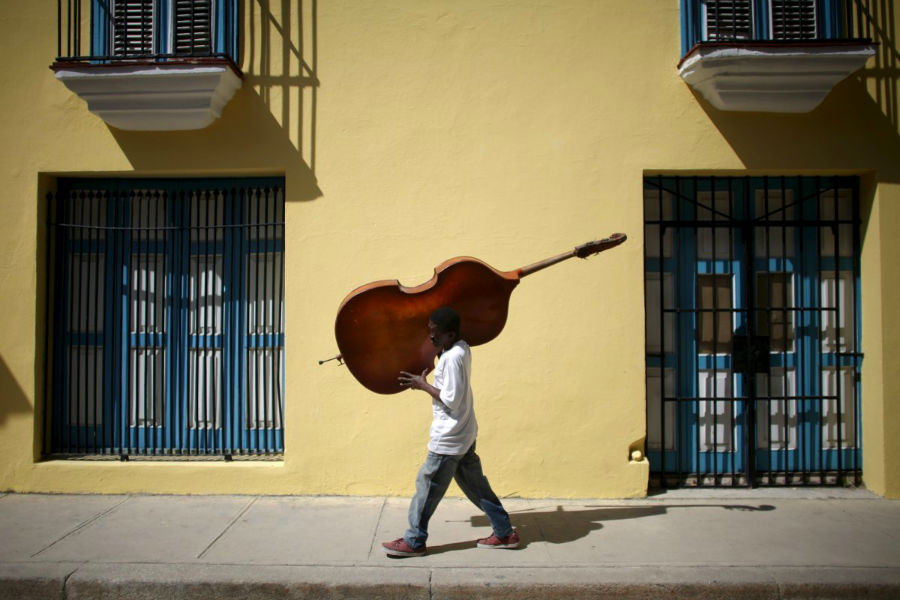 آهنگساز و نوازنده ای به نام «فریلال اورتیز» در حال حمل ویولن سل خود در مرکز شهر هاوانا 16 مارس 2016