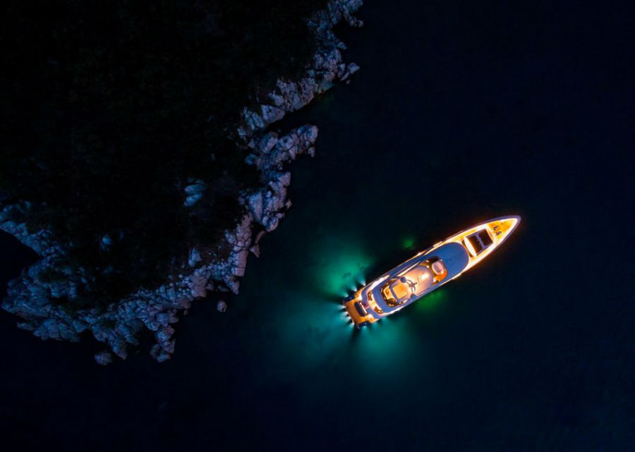 تصویر زیبای یک قایق تفریحی خصوصی در تاریکی شب روی آب ها