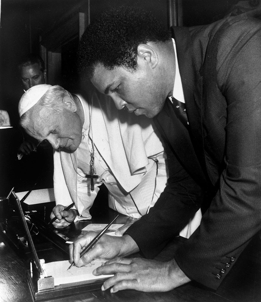 محمدعلی در حال امضا کردن در واتیکان سیتی در حضور پاپ جان پاول دوم
