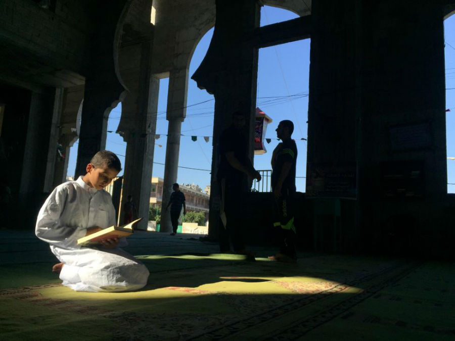 پسر نوجوان در حال مطالعه قرآن در مسجد در دومین جمعه از ماه مبارک رمضان عکاس: Suhaib Salem مکان: غزه، فلسطین 