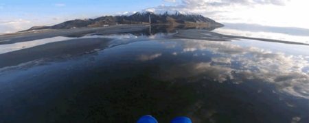 چتر سواری بر فراز دریاچه ای که همانند آینه بازتاب دهنده تصویر آسمان است [تماشا کنید]