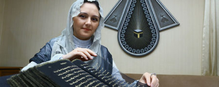 قرآنی که روی ۵۰ متر حریر و با جوهر طلا و نقره بازنویسی شده است