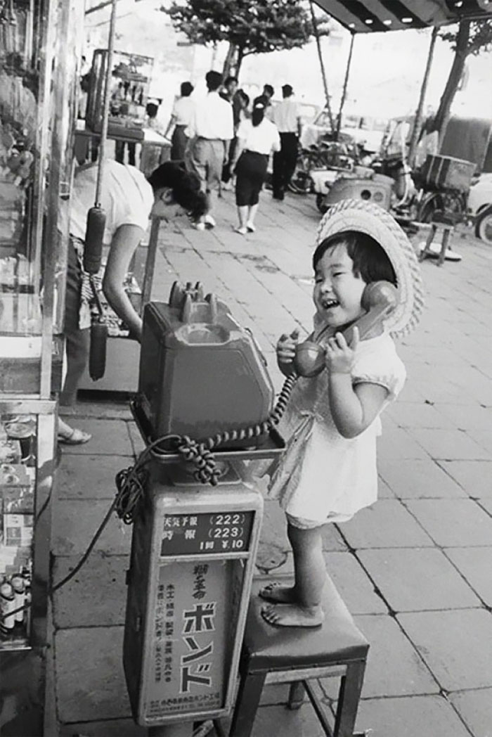 دختربچه خوشحالی که مثلا در حال صحبت کردن با تلفن است - ژاپن، 1958