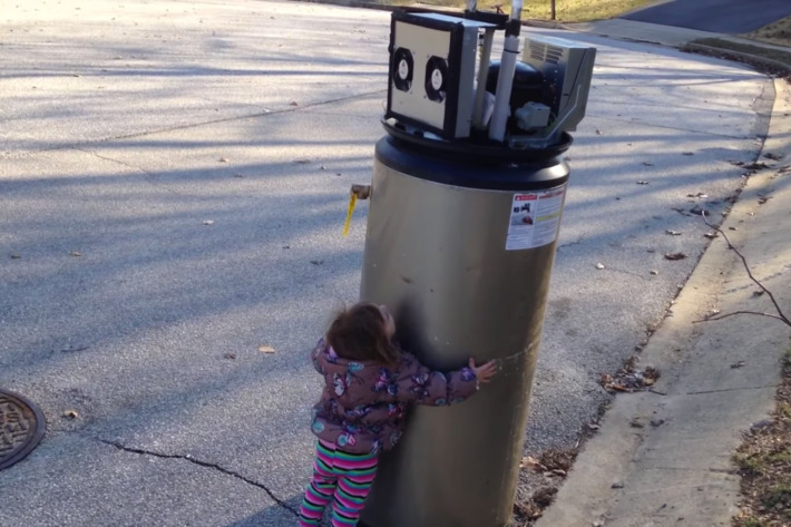 واکنش جالب دختر بچه ای که دستگاه آب گرم را با ربات اشتباه گرفته [تماشا کنید]