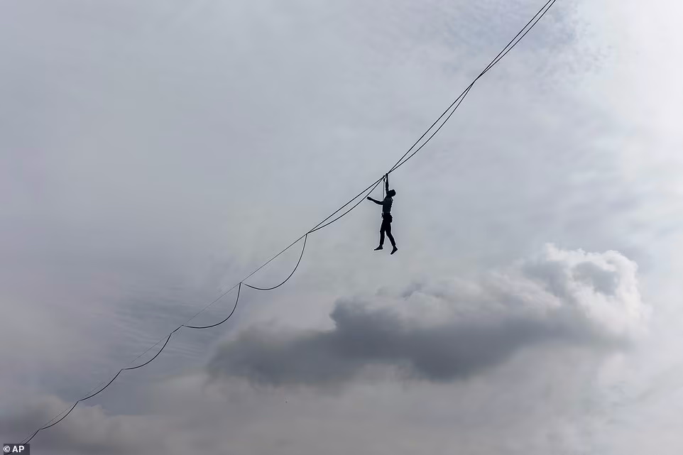 یک بندباز فرانسوی در حالی که روی یک طناب در ارتفاع 200 فوتی راه می رفت، از روی طنابی که از برج ایفل کشیده شده بود گذشت