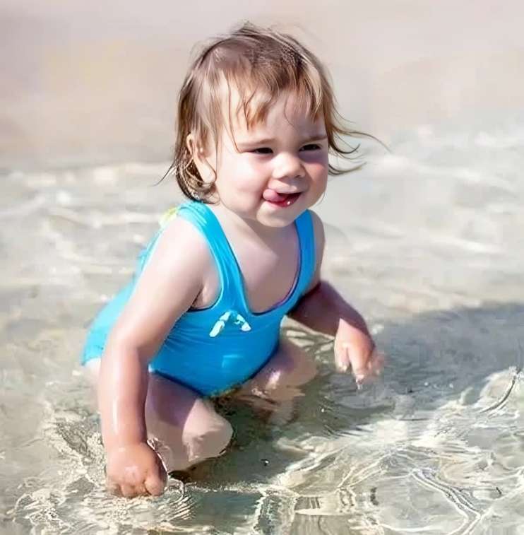1 little child girl in blue swimsuit is playing in sea water 1