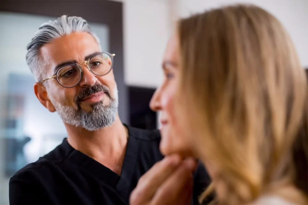پزشک در حال بررسی گونه بیمار برای عمل لیفت گونه